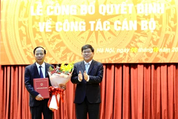 PGS, TS Nguyễn Duy Bắc, Phó Bí thư Đảng ủy, Phó Giám đốc Học viện Chính trị quốc gia Hồ Chí Minh trao quyết định và tặng hoa chúc mừng PGS, TS Mai Đức Ngọc.
