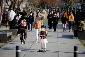 Một bé gái đeo khẩu trang đi xe đẩy tại một công viên ở Seoul, Hàn Quốc. Ảnh: Reuters.