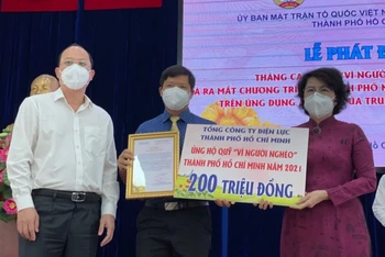 Ông Lê Văn Minh (giữa), Chủ tịch Công đoàn EVNHCMC trao 200 triệu ủng hộ Quỹ vì người nghèo TP Hồ Chí Minh.