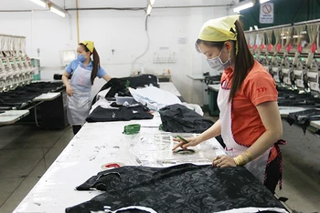 Công nhân Công ty TNHH Thêu Vĩnh Dương (quận Tân Phú, TP Hồ Chí Minh) duy trì sản xuất trong những ngày dịch Covid-19.