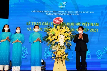 Phó Thủ tướng Thường trực Phạm Bình Minh trao lẵng hoa tặng Hội Liên hiệp Phụ nữ Việt Nam.