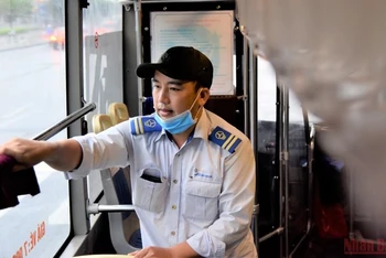 Nhân viên phục vụ trên xe buýt lau rửa nội thất phương tiện từ 4 giờ sáng, trước khi phục vụ người dân. (Ảnh: Minh Duy/NDĐT)
