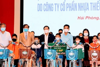 Đại diện Công ty cổ phần Nhựa Tiền Phong trao tặng xe đạp cho các em học sinh có hoàn cảnh khó khăn. (Ảnh: NGÔ QUANG DŨNG) 