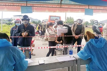Người dân làm thủ tục tại chốt kiểm soát phòng, chống dịch trên Quốc lộ 20 để vào tỉnh Lâm Đồng.