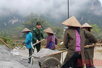 Thượng tá Mê Văn Đạt, Bí thư Đảng ủy xã Đàm Thủy cùng làm đường với dân. Ảnh: NGUYÊN PHONG