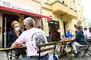 Người dân được tư vấn y tế trước khi tiêm vaccine tại quán bar Revolte, Berlin, Đức, ngày 13/6. (Ảnh: Reuters)