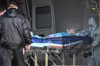 Nhân viên y tế chuyển bệnh nhân Covid-19 tới bệnh viện ở Moskva, Nga. (Ảnh: AFP/TTXVN)
