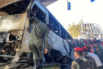 Lực lượng an ninh kiểm tra hiện trường vụ đánh bom nhằm vào xe buýt quân sự ở trung tâm Damascus (Syria) ngày 20/10/2021. (Nguồn: Reuters)