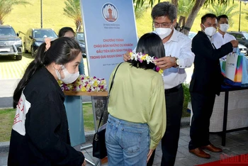 Phó Chủ tịch UBND tỉnh Bình Thuận Nguyễn Minh trao hoa chào mừng những du khách đầu tiên đến Bình Thuận trong trạng thái bình thường mới.