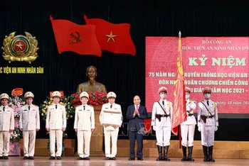 Chủ tịch nước Nguyễn Xuân Phúc trao tặng Huân chương Chiến công hạng Nhất cho Học viện An ninh nhân dân. (Ảnh: TTXVN)