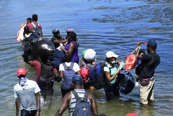 Người di cư băng qua sông ở bang Coahuila, Mexico. (Ảnh: AFP/TTXVN)