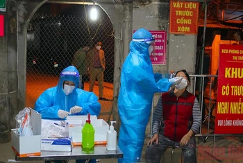 Lực lượng chức năng khẩn trương lấy mẫu xét nghiệm cho người dân thị trấn Quốc Oai ngay trong đêm.