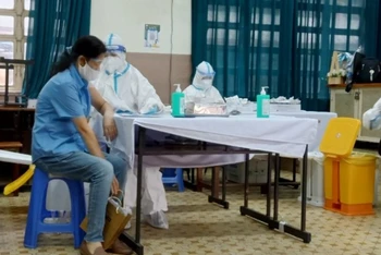 Người dân tiêm vaccine phòng Covid-19 tại điểm tiêm Trường THPT Nguyễn Thượng Hiền, quận Tân Bình, TP Hồ Chí Minh.