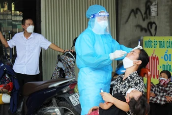 Cán bộ y tế lấy mẫu xét nghiệm sàng lọc Covid-19 trong cộng đồng ở huyện Quảng Xương.