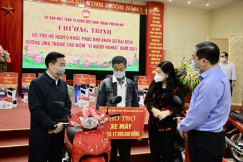 Lãnh đạo Ủy ban Mặt trận Tổ quốc Việt Nam thành phố Hà Nội trao tặng xe máy tới hộ gia đình có hoàn cảnh khó khăn.