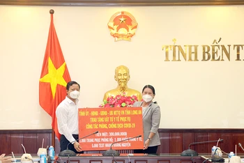 Phó Chủ tịch UBND tỉnh Bến Tre Nguyễn Thị Bé Mười tiếp nhận hỗ trợ từ Phó Chủ tịch UBND tỉnh Long An Phạm Tấn Hòa.
