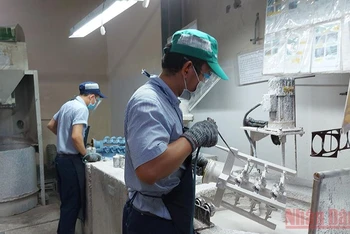 Công nhân sản xuất ổn định trở lại tại doanh nghiệp đóng trong Khu chế xuất Tân Thuận, quận 7. 