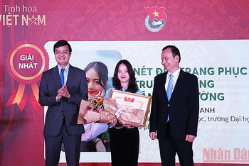 Đồng chí Bùi Quang Huy, Ủy viên dự khuyết Trung ương Đảng, Bí thư thường trực Trung ương Đoàn, Chủ tịch Hội Sinh viên Việt Nam (bên trái) trao giải nhất tặng tác giả Bùi Mai Anh. 