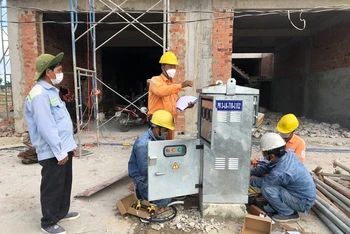 Nhân viên Công ty TNHH MTV Điện lực Đồng Nai gắn điện kế cho người dân trong khu tái định cư Lộc An – Bình Sơn.