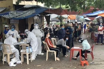 Lực lượng y tế tổ chức lấy mẫu xét nghiệm sàng lọc với toàn bộ tiểu thương chợ Hành Thiện, xã Xuân Hồng, huyện Xuân Trường (Nam Định).