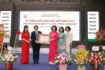 Đại diện Bộ Giáo dục và Đào tạo thừa ủy quyền của Thủ tướng Chính phủ trao Bằng khen cho tập thể cán bộ giáo viên Trường tiểu học Lê Văn Tám.