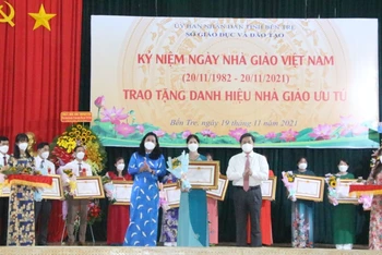 Bí thư Tỉnh ủy Bến Tre Lê Đức Thọ và Phó Chủ tịch UBND tỉnh Bến Tre Nguyễn Thị Bé Mười trao danh hiệu “Nhà giáo ưu tú” cho thầy, cô giáo.