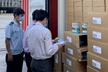 Lấy mẫu kiểm tra lô 22.000 hộp sữa tại cảng Cát Lái chiều 12/11. (Ảnh: Cục Hải quan TP Hồ Chí Minh)