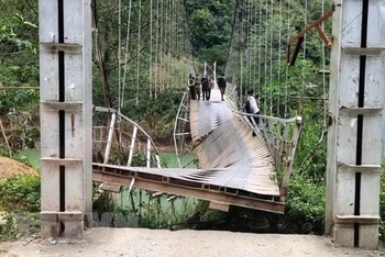 Cầu treo Nam Quang bị đứt gãy làm xe tải chở hàng rơi xuống sông. (Ảnh: TTXVN)