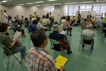 Người dân xếp hàng chờ tiêm vaccine phòng Covid-19 tại Tokyo (Nhật Bản), ngày 24/5/2021. (Ảnh: AFP/TTXVN)