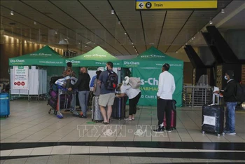 Hành khách xếp hàng chờ xét nghiệm Covid-19 tại sân bay ở Johannesburg, Nam Phi, ngày 27/11. (Ảnh: AFP/TTXVN)