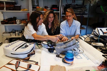 Ba chị em gái, ba nhà sáng lập hãng thời trang đang trao đổi về thiết kế của các sản phẩm từ túi thải. (Ảnh: Reuters)