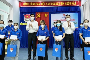 Đồng chí Nguyễn Minh Triết (áo trắng, bên trái trong ảnh) cùng đại diện lãnh đạo tỉnh Bình Định trao học bổng tặng học sinh, sinh viên tại chương trình.