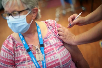 Một phụ nữ người Anh được tiêm liều vaccine tăng cường. Ảnh: Reuters.