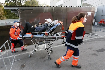 Nhân viên y tế chuyển bệnh nhân Covid-19 tới bệnh viện tại Bucharest, Romania, ngày 4/11/2021. (Ảnh: THX/TTXVN)
