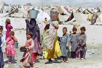 Trẻ em Afghanistan lấy nước tại một trại tị nạn ở Jalalabad, Afghanistan. (Ảnh: AFP/TTXVN)