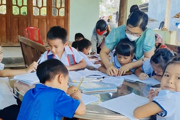 Cô giáo Trường tiểu học Thanh An hướng dẫn học sinh tại các điểm trường trong thôn. 