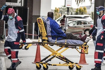Nhân viên y tế chuyển bệnh nhân mắc Covid-19 vào 1 bệnh viện ở Port Elizabeth, Nam Phi. (Ảnh: TTXVN)