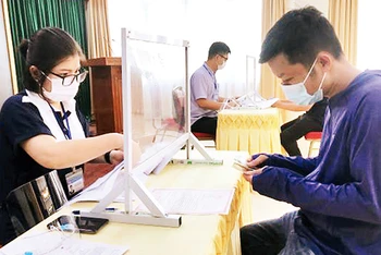 Người lao động ở quận Hoàn Kiếm nhận tiền từ gói hỗ trợ 26 nghìn tỷ đồng. (Ảnh: Thủy Trúc)