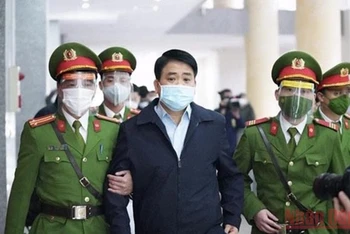 Lực lượng chức năng dẫn giải ông Nguyễn Đức Chung đến Tòa án. 