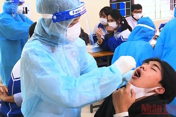 Lấy mẫu xét nghiệm sàng lọc Covid-19 cho học sinh ở huyện Hậu Lộc.