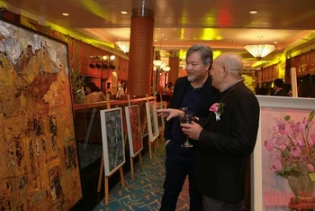 Người xem thích thú trao đổi về những bức tranh đẹp tại triển lãm.