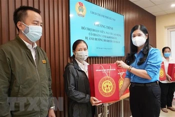 Lãnh đạo Liên đoàn Lao động thành phố Hà Nội tặng quà cho đoàn viên công đoàn, người lao động bị ảnh hưởng do dịch Covid-19 trên địa bàn quận Hoàn Kiếm. (Ảnh: TTXVN)