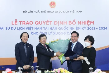 Thứ trưởng Đoàn Văn Việt (bên trái) trao hoa và Quyết định bổ nhiệm Đại sứ Du lịch Việt Nam tại Hàn Quốc cho ông Lý Xương Căn (phải) (Ảnh: NGUYỄN NAM)
