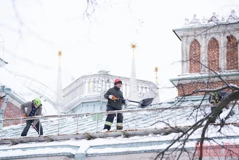 Công nhân dọn tuyết trên mái nhà ở thủ đô Moskva của Nga. (Ảnh: Thanh Thể)
