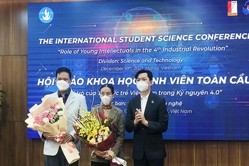 Đồng chí Nguyễn Minh Triết (bên phải trong ảnh) trao hoa tặng các đại biểu trí thức trẻ tham gia Hội thảo tại đầu cầu thành phố Hà Nội.