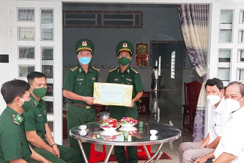 Đại tá Lê Văn Anh, Phó Chính ủy Bộ đội Biên phòng tỉnh Sóc Trăng trao quyết định bàn gia nhà đồng đội cho đồng chí Trung tá Lâm Chí Dũng.