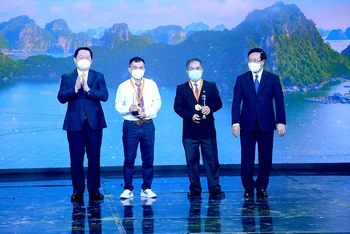 Các đồng chí Phạm Bình Minh, Nguyễn Trọng Nghĩa trao giải Nhất cho các tác giả.