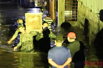 Cán bộ chiến sĩ Bộ chỉ huy Quân sự tỉnh Phú Yên giúp người dân có nhà bị triều cường gây ngập đến nơi an toàn.