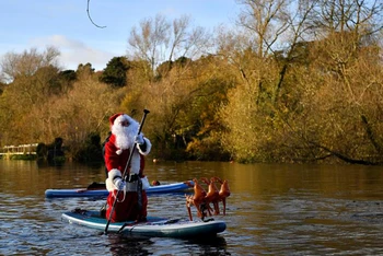 Hóa trang thành ông già Noel và dùng ván lướt sóng di chuyển trên sông Liffey, thành phố Dublin, Ireland, để mang đến niềm vui Giáng sinh trong không khí ảm đạm của đại dịch Covid-19.