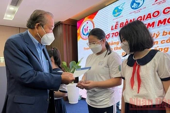 Đồng chí Trương Hòa Bình, nguyên Ủy viên Bộ Chính trị, nguyên Phó Thủ tướng thường trực Chính phủ trao quà cho các em học sinh khó khăn do ảnh hưởng của dịch Covid-19.